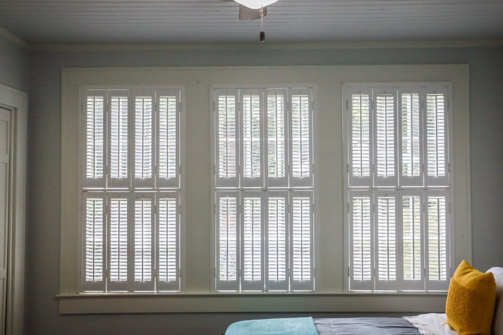Sunlit bedroom with white plantation shutters