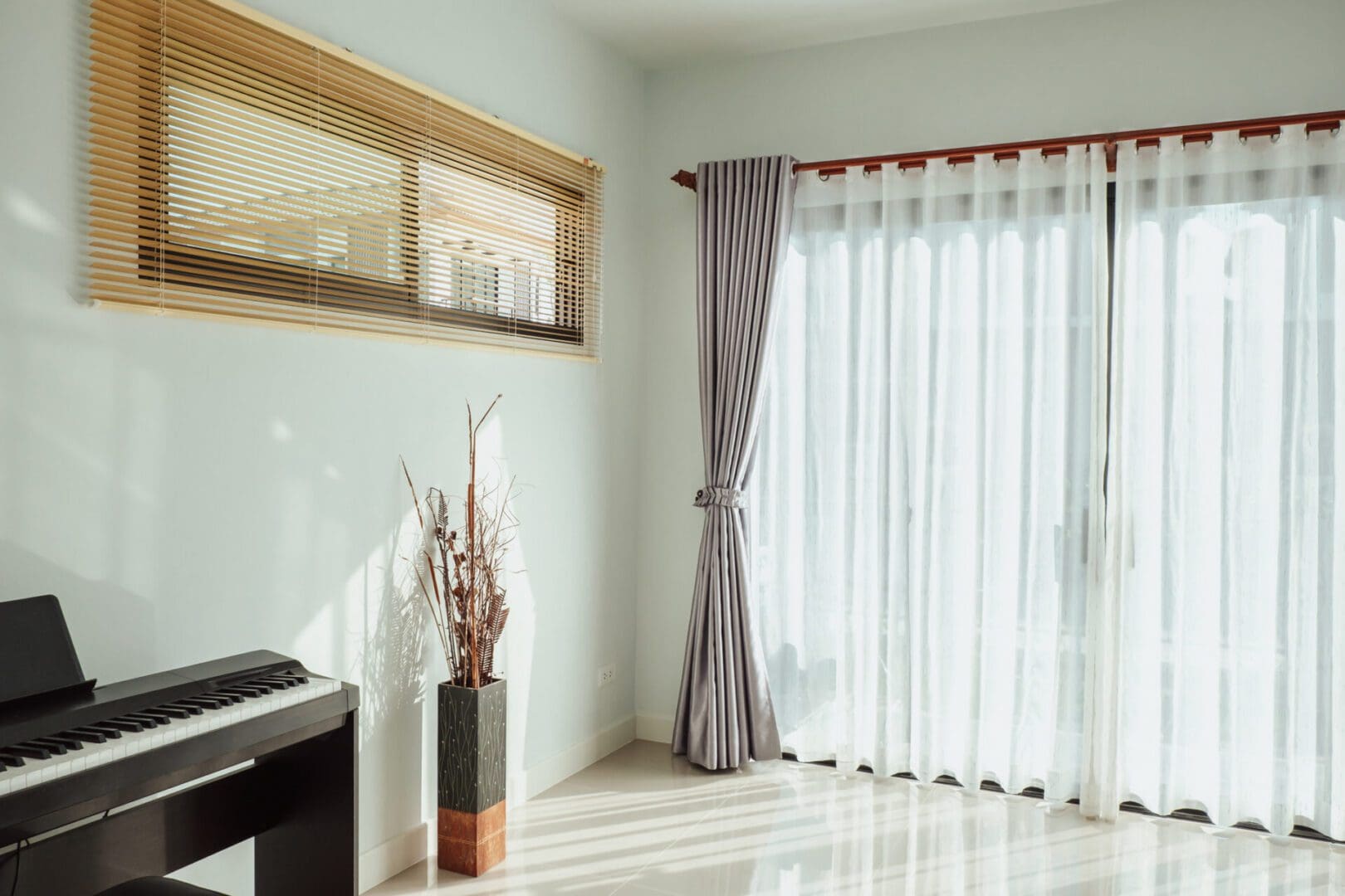 Sunlit room with keyboard, vase, sheer curtains