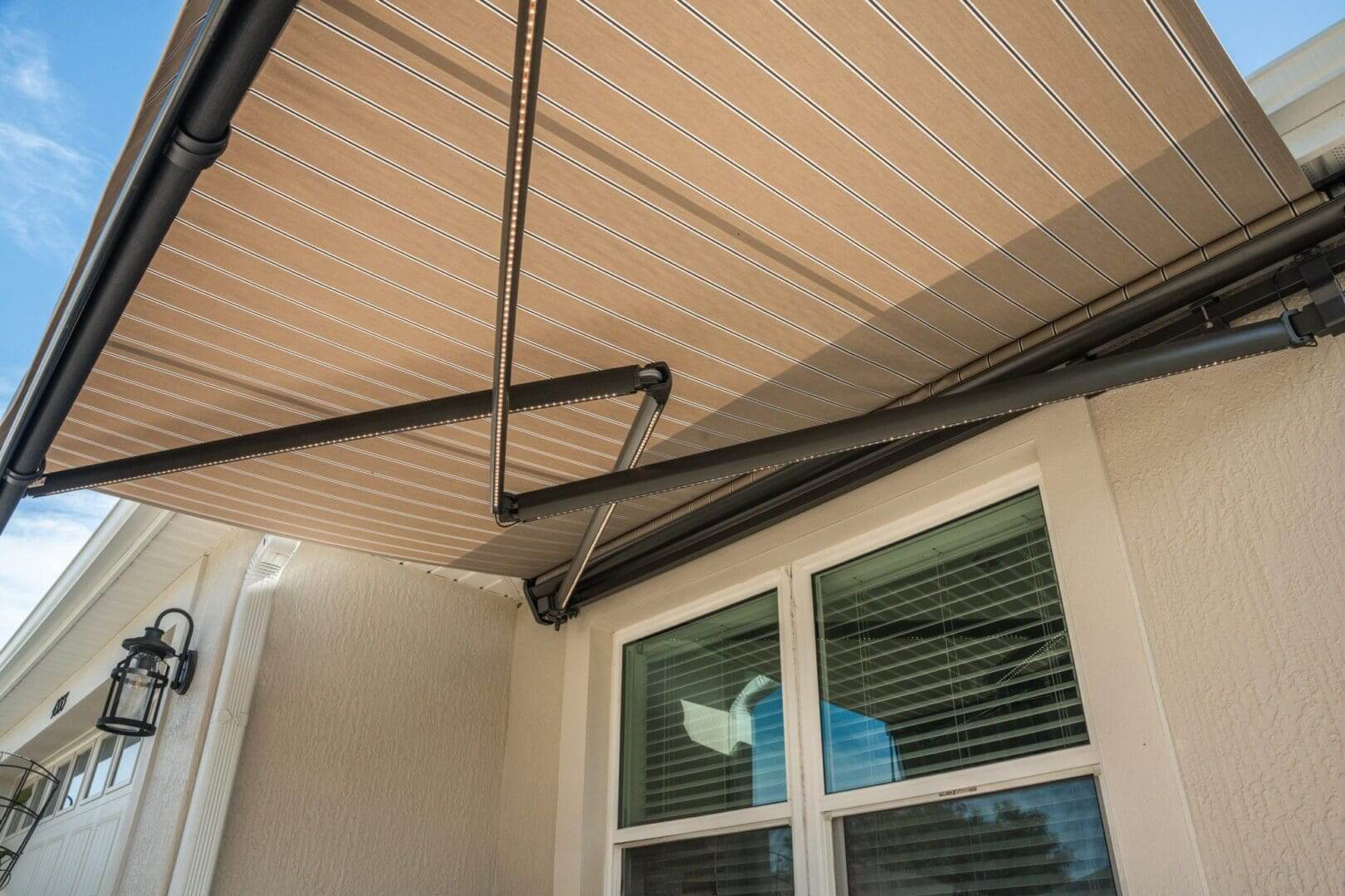 Beige striped retractable awning over window