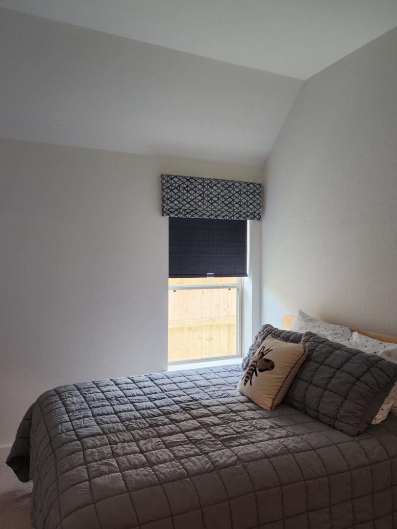 Cozy small bedroom with gray quilt and pillows
