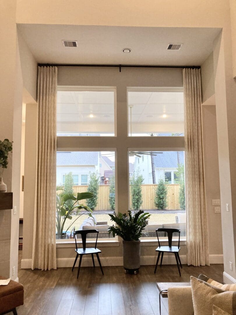 Large living room window with chairs and plants